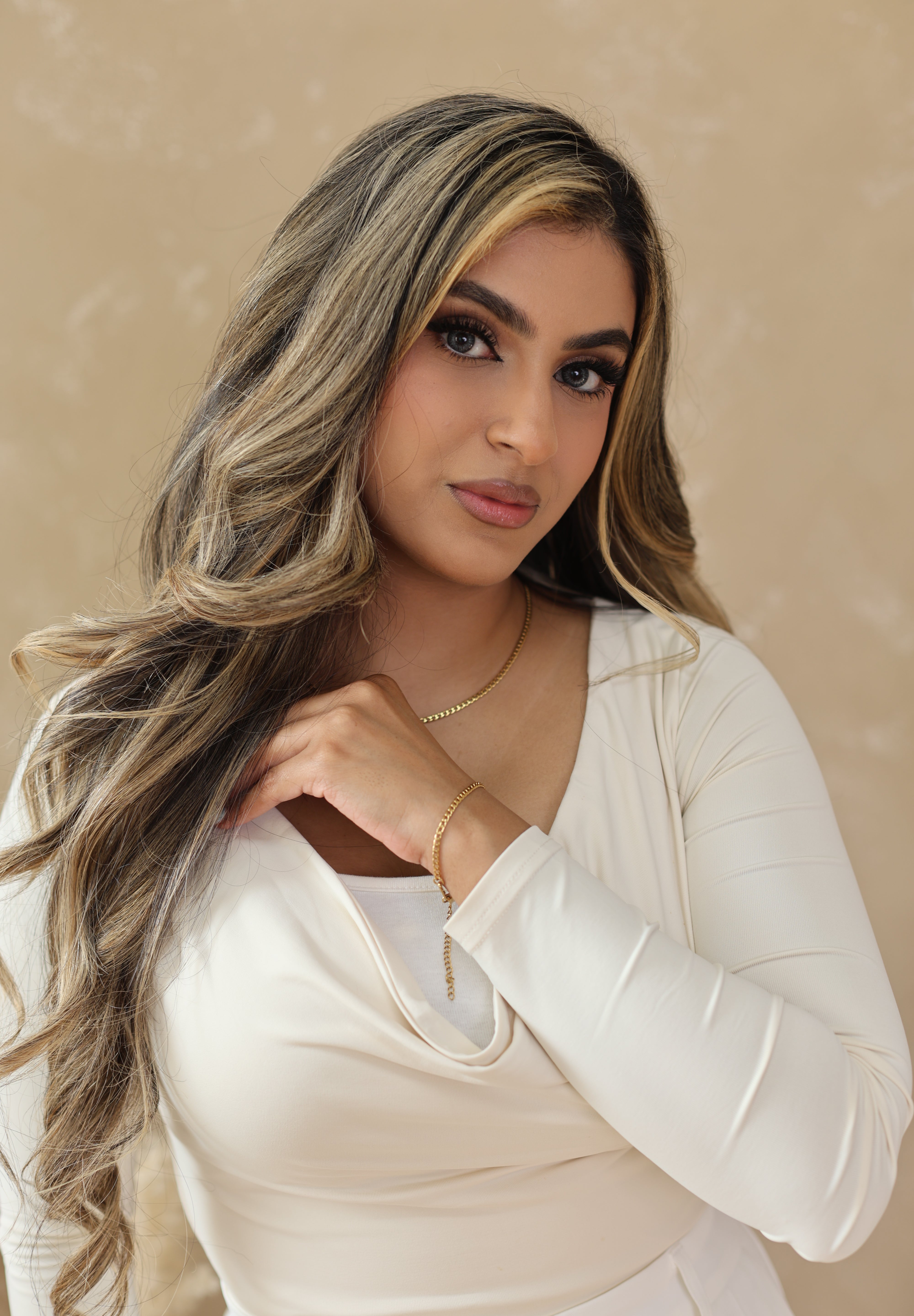 Woman with styled hair against a beige background